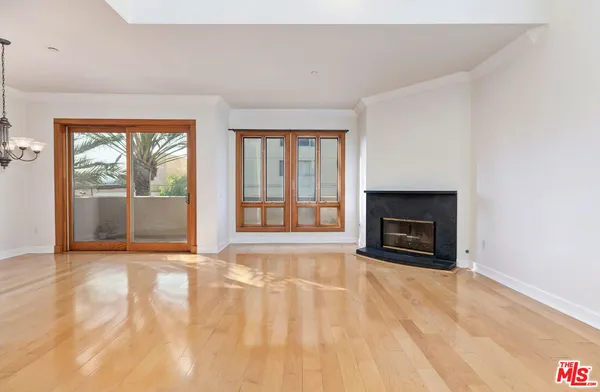 a view of an empty room with a fireplace and a window