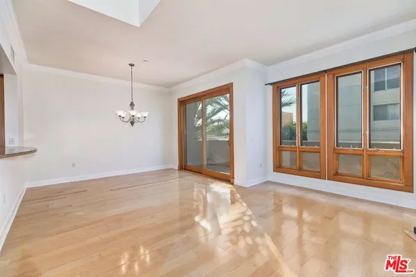 a view of an empty room with glass door and balcony