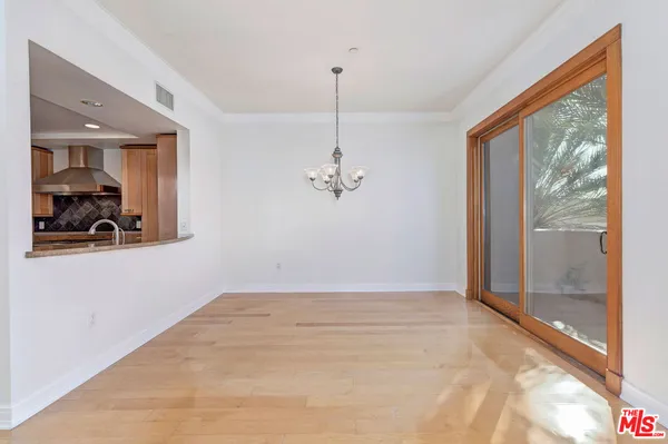 a view of a room with wooden floor ceiling fan and windows