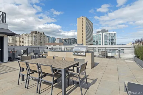 a view of a roof deck with dining table and chairs