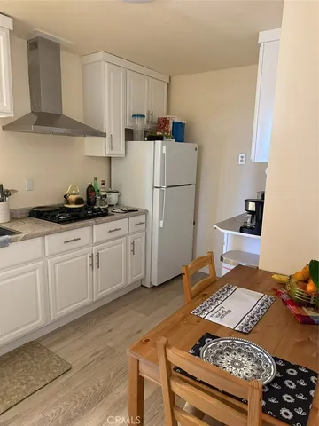 a kitchen with a stove a refrigerator and cabinets