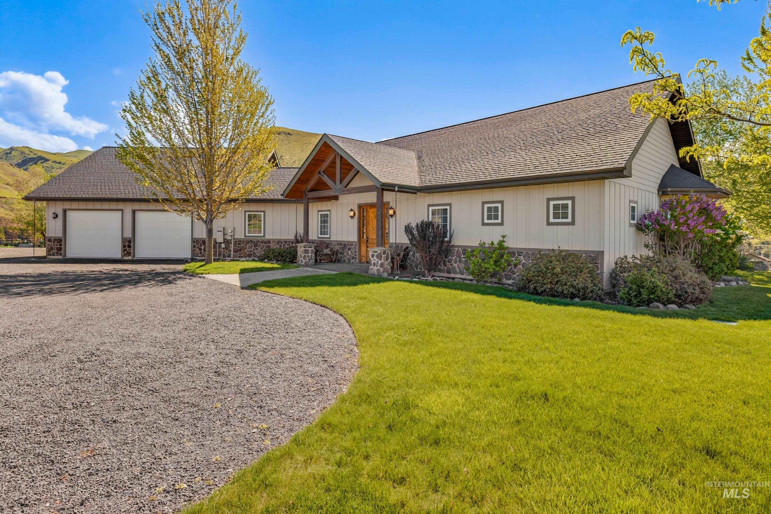 113 Deford Road White Bird, ID 83554 - Photo 36 of 49 Ranch-style residence featuring a two-car garage, stone facade accents, and a covered entry with exposed wood beams