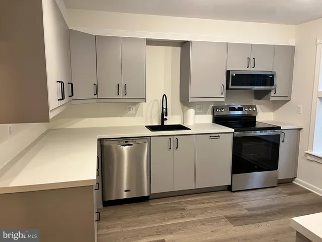 a kitchen with stainless steel appliances white cabinets and a sink