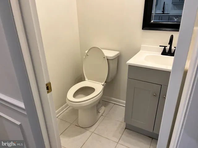 a white toilet sitting next to a sink and a mirror