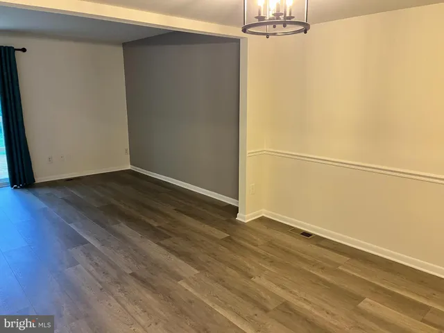 a view of a room with wooden floor