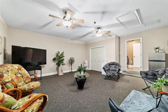 a living room with furniture a flat screen tv and a chandelier