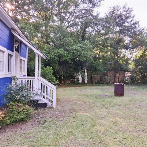 a view of a house with backyard and trees