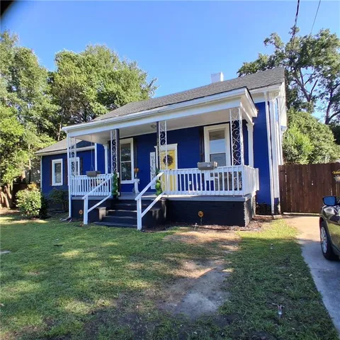 a view of a house with a yard and sitting area