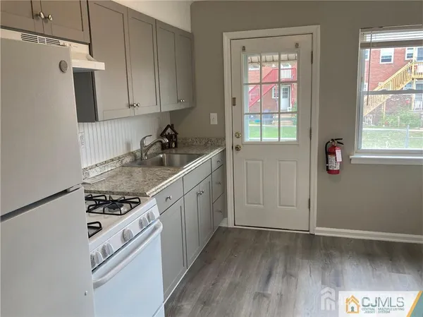 a kitchen with stainless steel appliances a white cabinets and a window