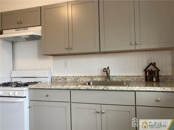 a kitchen with granite countertop cabinets and white appliances