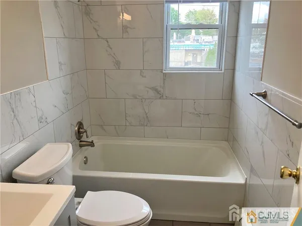 a bathroom with a toilet bathtub window and shower