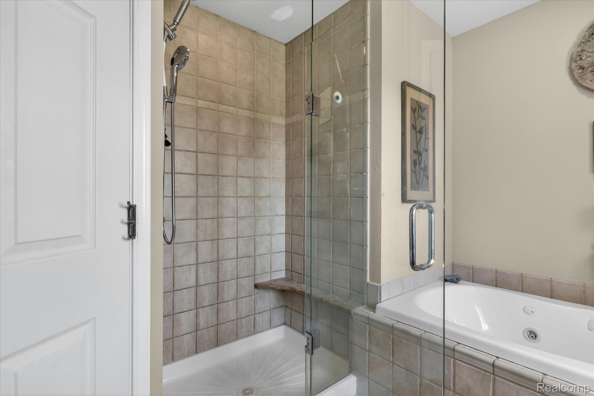 3860 East Commerce Road Commerce Township, MI 48382 - Photo 31 of 72 Tiled shower enclosure with built-in bench and glass door, featuring a handheld showerhead