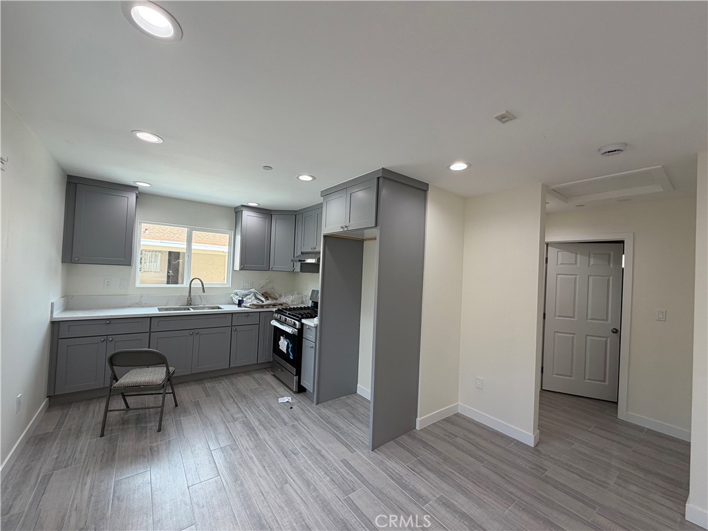 321 Elm Street Alhambra, CA 91801 - Photo 5 of 11 a kitchen with stainless steel appliances granite countertop a refrigerator a sink dishwasher a stove and a dining table with wooden floor