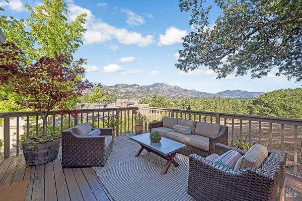 a roof deck with couches and wooden floor