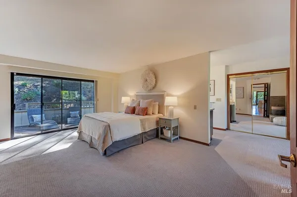 a spacious bedroom with a bed lamp and large window