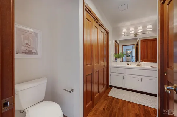 a bathroom with a granite countertop toilet sink and mirror