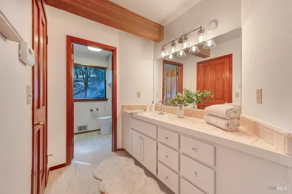 a en suite bathroom with a granite countertop sink and a mirror