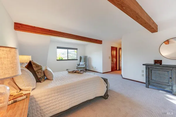 a bedroom with a bed and dresser with mirror