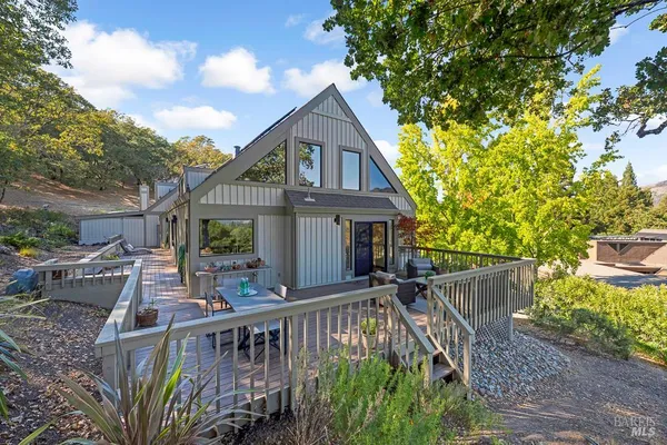 a front view of house with deck and yard