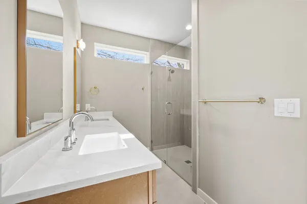 a bathroom with a sink a toilet and shower