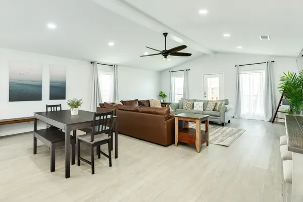 a living room with furniture a window and a flat screen tv