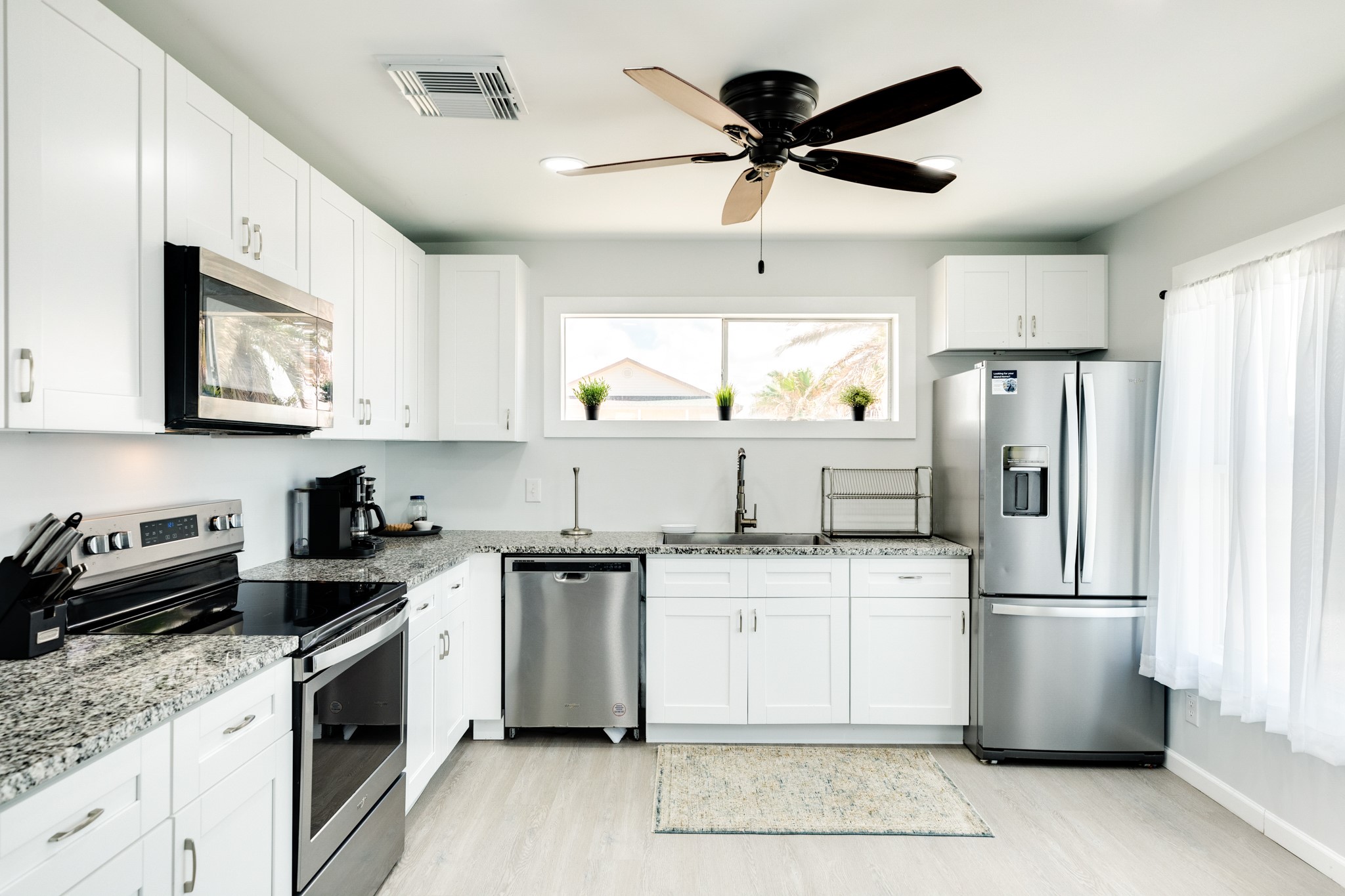 315 Seashell Drive Surfside Beach, TX 77541 - Photo 11 of 33 a kitchen with a sink a refrigerator a microwave and cabinets