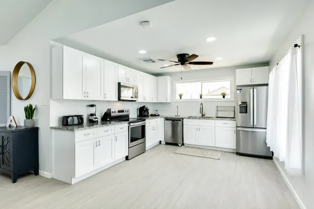 a kitchen with white cabinets and white appliances