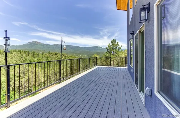 a view of a balcony with wooden floor next to a yard
