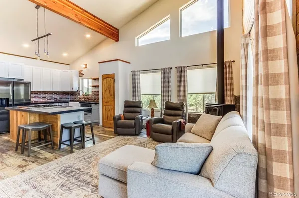 a living room with furniture and a open kitchen view