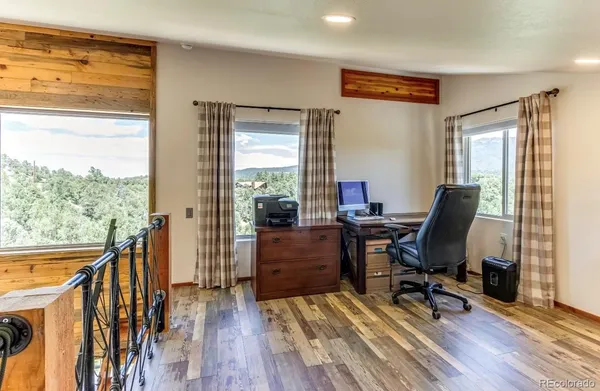a view of a workspace with wooden floor and a window