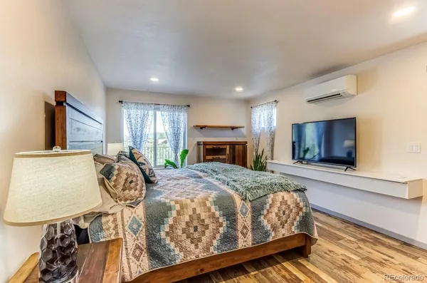 a spacious bedroom with a bed and a flat screen tv