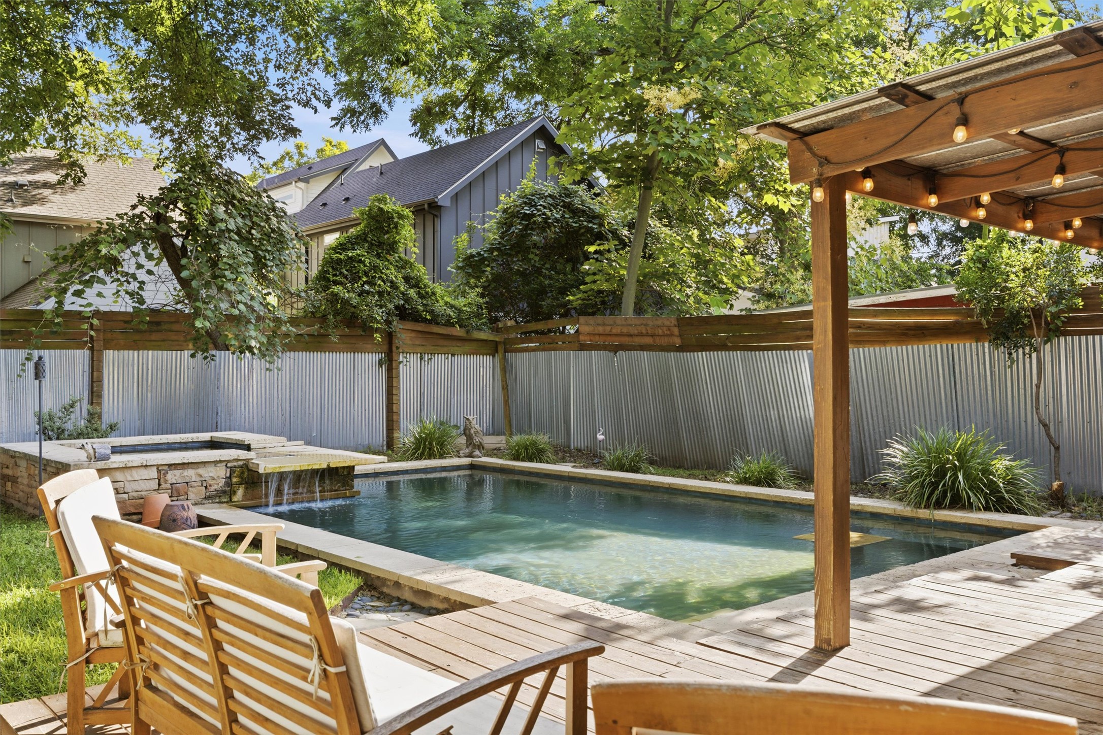 3015 Castro Street Austin, TX 78702 - Photo 32 of 40 An inviting backyard oasis awaits with a sparkling pool and spa, framed by mature trees.