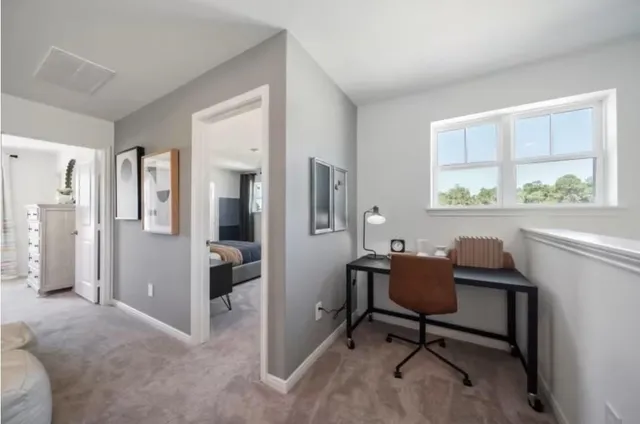 a view of a workspace with furniture and a window