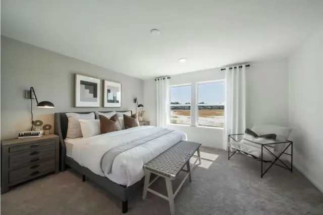 a bedroom with a bed a table and chair