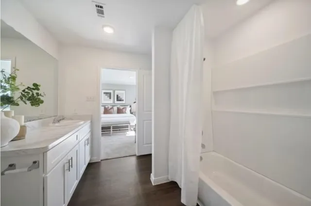 a bathroom with a bathtub sink and mirror