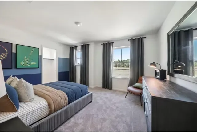 a spacious bedroom with a bed and wooden floor