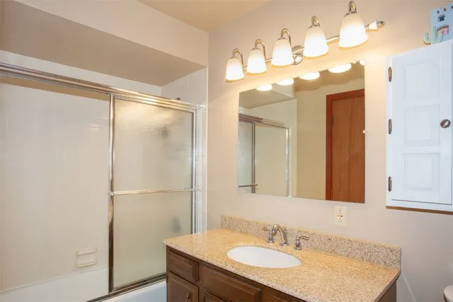 a bathroom with a sink vanity granite and a mirror