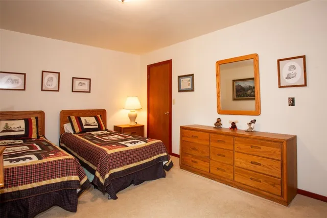 a bedroom with two beds and painting on the wall