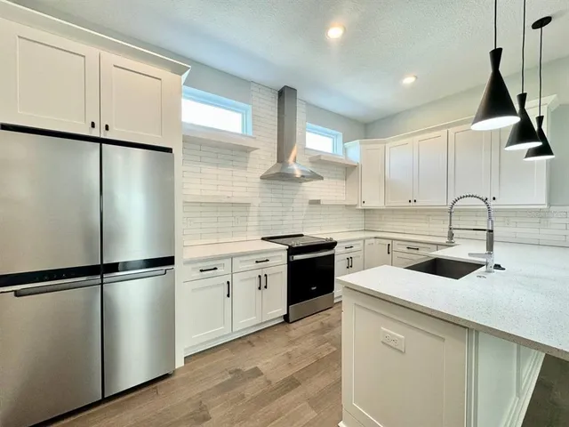 a kitchen with a refrigerator sink and cabinets