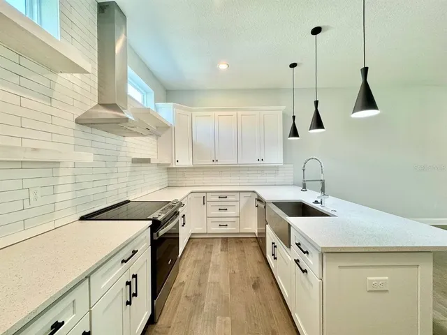 a kitchen with a sink a stove and cabinets