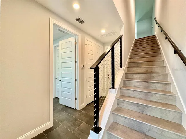 a view of staircase with wooden floor and white walls