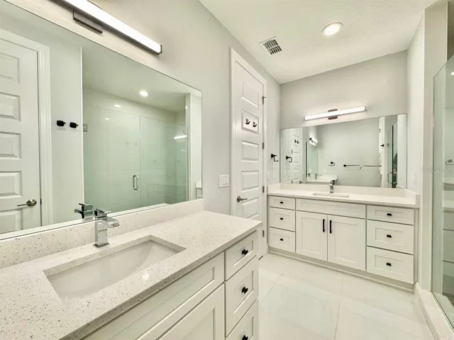 a spacious bathroom with a granite countertop sink mirror shower and