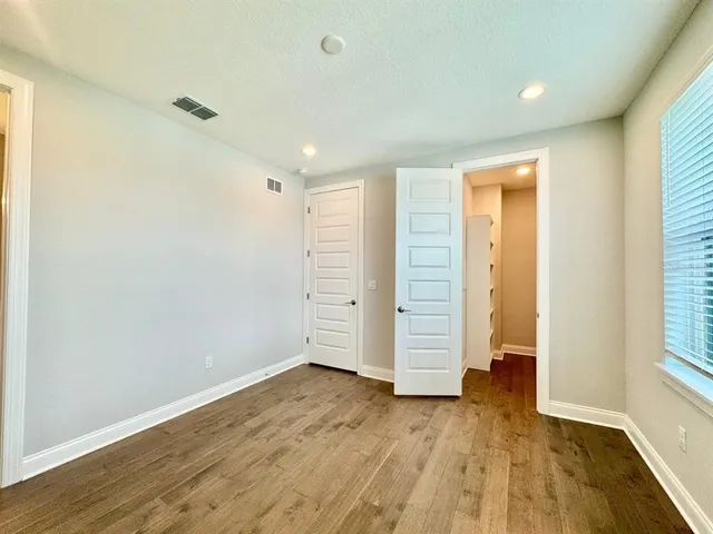 an empty room with wooden floor and window
