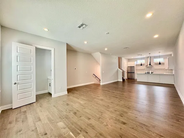 a view of kitchen and hall with wooden floor