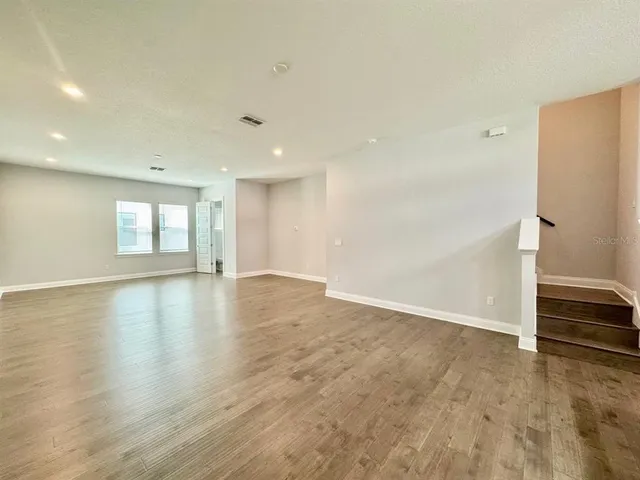 an empty room with wooden floor and window