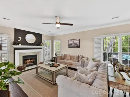 a living room with furniture a fireplace and a large window
