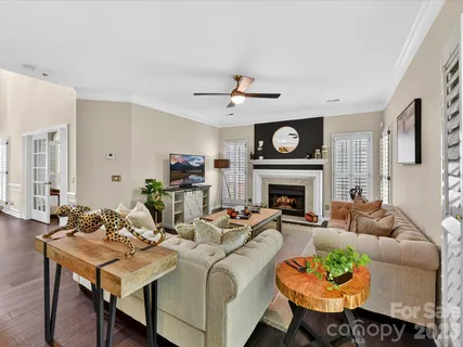 a living room with furniture a fireplace a clock and a large window