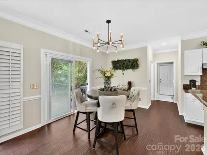 a view of a dining room with furniture a chandelier and wooden floor