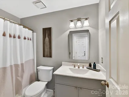 a bathroom with a sink vanity mirror and toilet