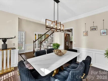 a view of a dining room and livingroom with furniture wooden floor a chandelier